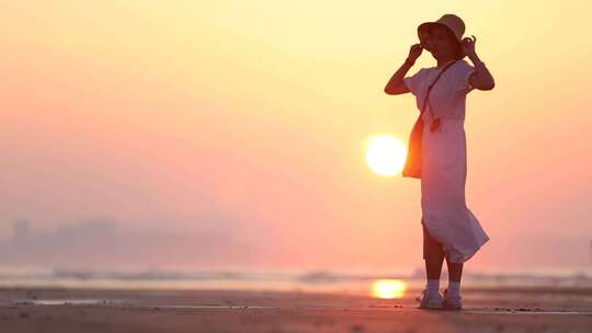 烟台夏天海边落日夕阳，女孩在沙滩上走动