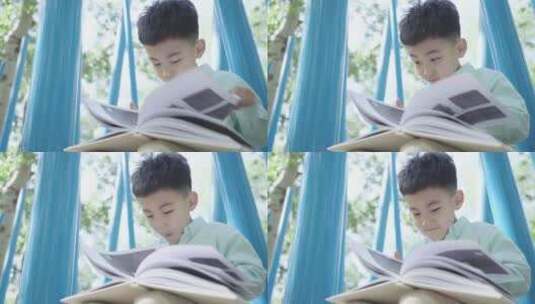 小男孩坐在户外看书高清在线视频素材下载
