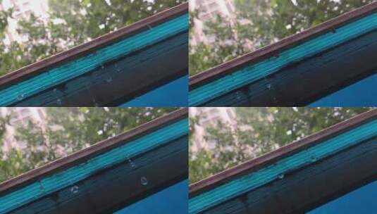 蓝色房檐下的雨滴慢动作高清在线视频素材下载