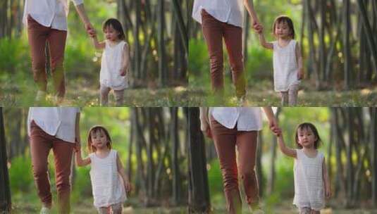 小女孩和妈妈在一起牵手走在公园里高清在线视频素材下载