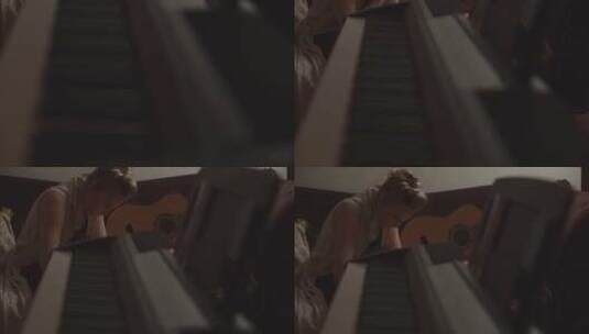 坐在键盘和原声吉他之间写作的女人高清在线视频素材下载