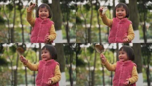 小女孩在秋天的公园里拿着一片树叶玩耍高清在线视频素材下载