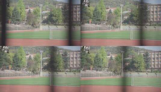 隔着护栏拍摄校园运动场足球场高清在线视频素材下载