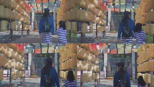 行人穿行挂有灯笼的通道高清在线视频素材下载