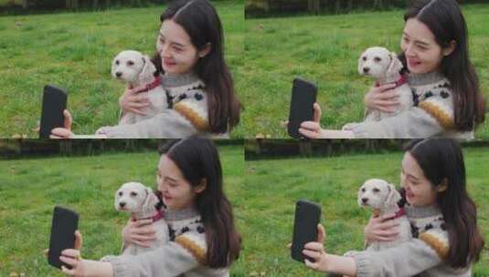 女孩抱着宠物犬在公园里玩耍用手机自拍高清在线视频素材下载