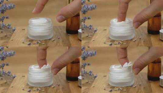 女人用手指从玻璃罐中取出白色面霜高清在线视频素材下载