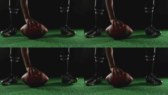 美国橄榄球运动员弯着腰用手在草坪上持球高清在线视频素材下载