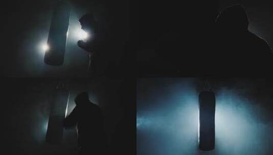 拳击手在昏暗的健身房打拳击沙袋高清在线视频素材下载