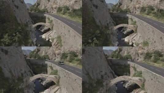 山谷中公路和旁边的石拱桥高清在线视频素材下载