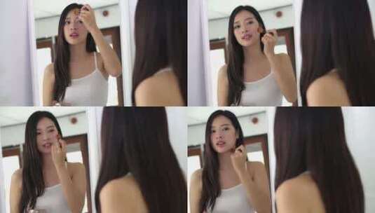 美容肖像亚洲女人用脸颊刷化妆在室内照镜子。高清在线视频素材下载