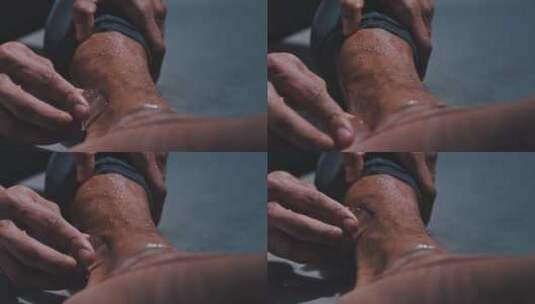 男子用冰块擦拭脚腕儿特写高清在线视频素材下载