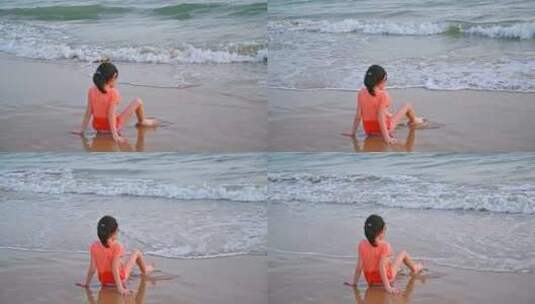 海南三亚坐在沙滩上快乐玩水的可爱女孩高清在线视频素材下载