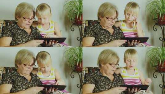 女孩和祖母玩平板电脑高清在线视频素材下载