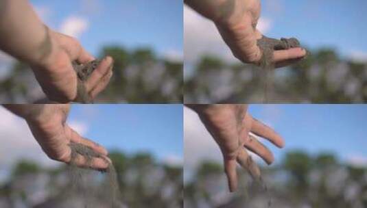 特写手抓起一把干沙子，让它落在他的手指之间高清在线视频素材下载