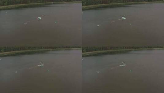 无人驾驶飞机拍摄了冲浪者女孩在船后长板上的照片，旁边是相机船高清在线视频素材下载