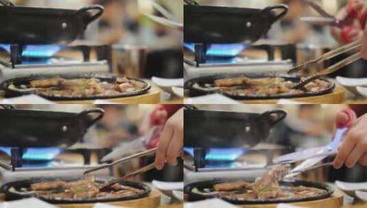 在餐厅里用剪刀和镊子把烤好的肉剪成小块高清在线视频素材下载