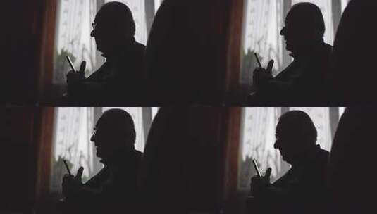 窗边有智能手机的老人高清在线视频素材下载