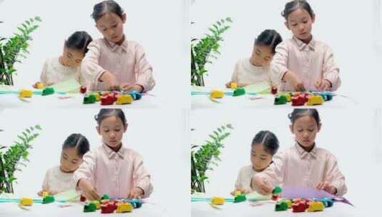 两名认真玩剪纸游戏的中国女孩高清在线视频素材下载