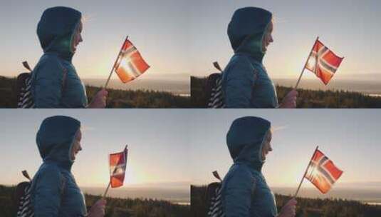 手里拿着挪威国旗的女孩在山顶遇见日出高清在线视频素材下载
