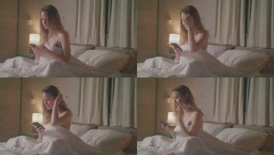 女孩坐在床上玩手机高清在线视频素材下载
