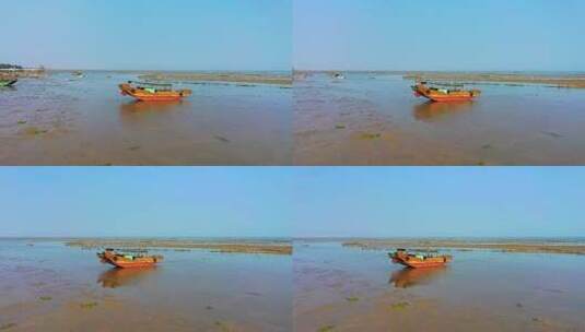 一艘停泊在海滩上的橘红色小船高清在线视频素材下载