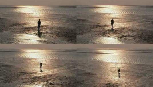 一个人行走在夕阳照耀下的沙滩上高清在线视频素材下载