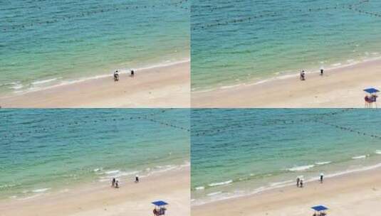 航拍蓝色大海沙滩海浪海岸线上行走的人高清在线视频素材下载