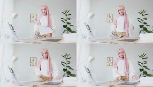头戴粉色头巾的女人正在整理桌上的杂志高清在线视频素材下载
