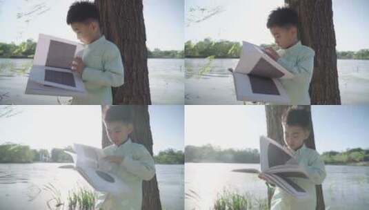 小男孩坐在户外看书高清在线视频素材下载