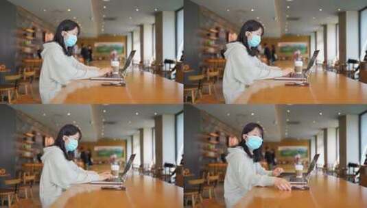 疫情带口罩年轻女子在咖啡店使用笔记本电脑高清在线视频素材下载