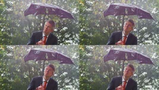 雨中商人躲在破雨伞下高清在线视频素材下载