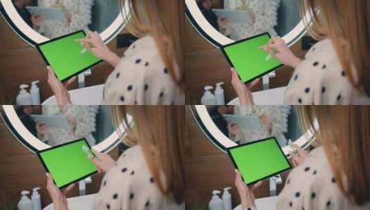 女人手里拿着一台带有绿色Chromakey屏幕的笔记本电脑。高清在线视频素材下载