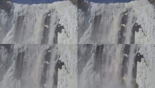 航拍被冰雪覆盖的溪流旁瀑布飞流直下高清在线视频素材下载