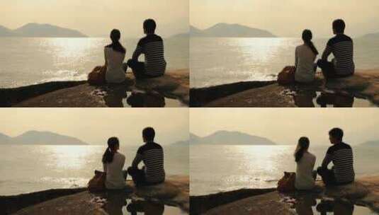 夫妇在海边欣赏日落下的海景高清在线视频素材下载