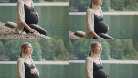 孕妇坐在山湖附近轻轻抚摸肚子高清在线视频素材下载