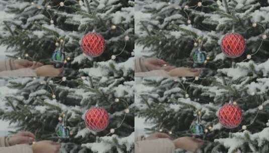 下雪天女人在松树上挂圣诞装饰高清在线视频素材下载