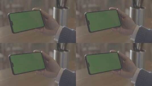 男性拿着绿色屏幕的手机高清在线视频素材下载