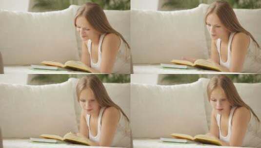 女孩躺在沙发上看书高清在线视频素材下载