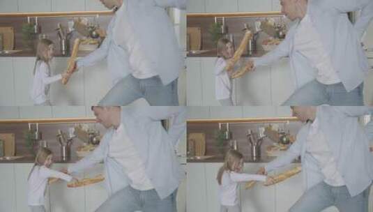 在厨房里和女孩拿面包棒玩耍的父亲高清在线视频素材下载