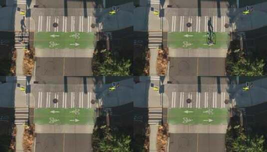 骑自行车的人通过使用自行车道的空置十字路口的自上而下的视图。高清在线视频素材下载