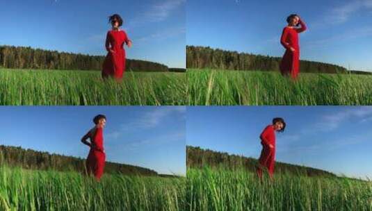 一个穿着红色连衣裙的迷人女人在一片新鲜的高清在线视频素材下载