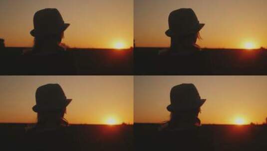 站在夕阳前戴着帽子的女人高清在线视频素材下载