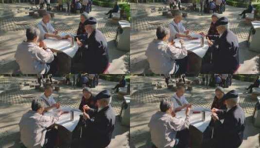 早晨老人在公园石桌上打牌下棋娱乐阳光01高清在线视频素材下载