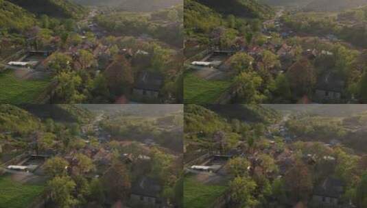 航拍横移俯瞰春天山野中的山谷村庄高清在线视频素材下载
