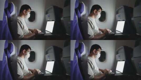 疫情期间男子在飞机上使用笔记本电脑高清在线视频素材下载