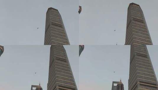 《仰拍高楼 飞机划过城市地标天际线》高清在线视频素材下载