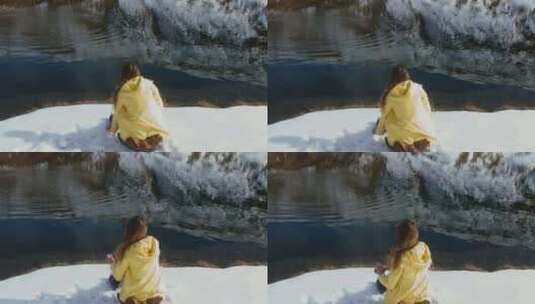 女孩坐在湖边把雪球扔进湖里高清在线视频素材下载