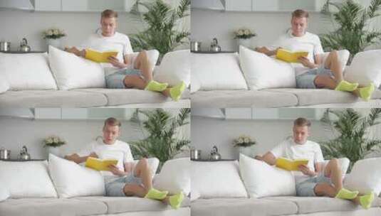 男人坐在沙发上看书高清在线视频素材下载