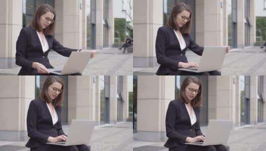 身着正式服装的妇女在办公楼外使用笔记本电脑高清在线视频素材下载
