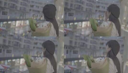 云南昆明一个女孩子抱着花在天台看风景高清在线视频素材下载